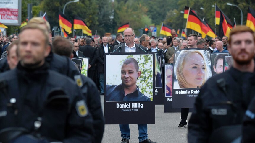 Protester with photo of murdered man Daniel Hillig