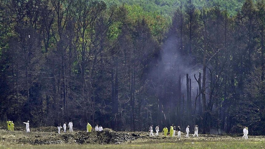 Investigative personnel search the crash site of United Airlines Flight 93 on September 12, 2001