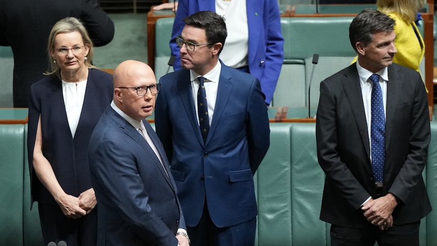 Coalition politicians stand on the floor of the house of representatives.