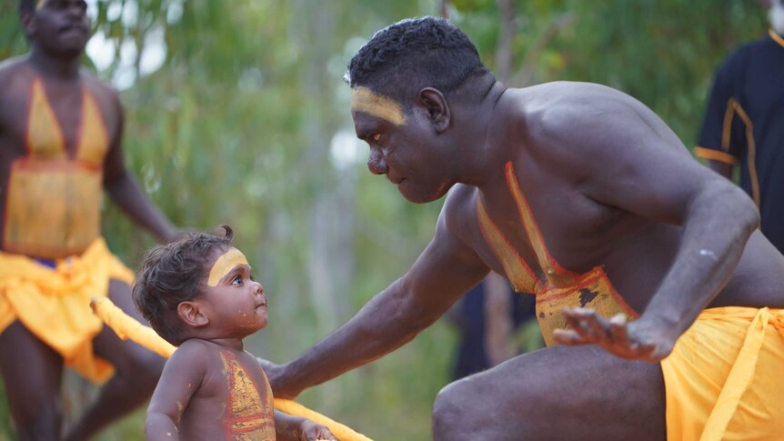 Toddler Joevhan Burarrwangam looks up at his father during a performance by the Gumatj clan.