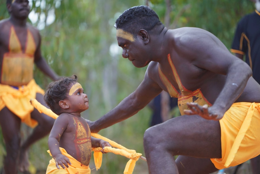 Toddler Joevhan Burarrwangam looks up at his father during a performance by the Gumatj clan.