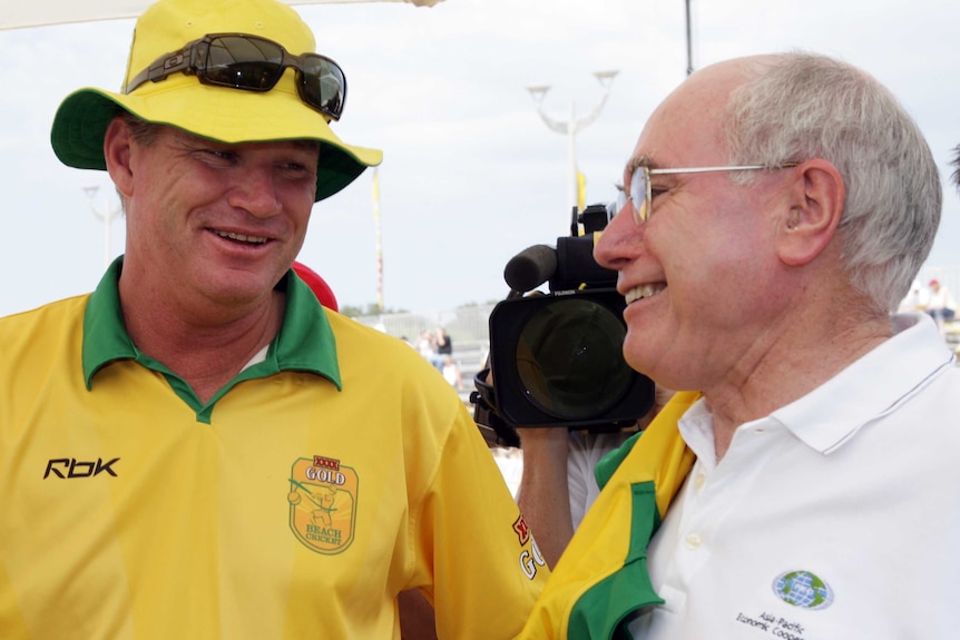A former Australian prime ministers chats with a former Australian cricketer at a beach cricket event in Sydney in 2007.