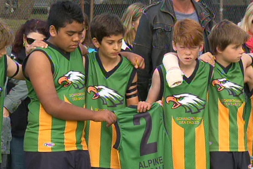 Mo Maslin's Scarborough Sea Eagles team mates hold up his playing shirt