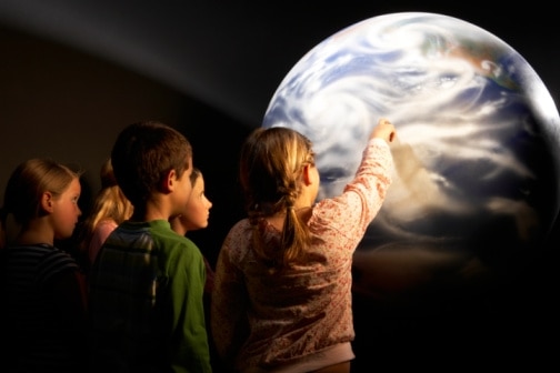 A group of children look at a model of the Earth. (Thinkstock: Nick White)