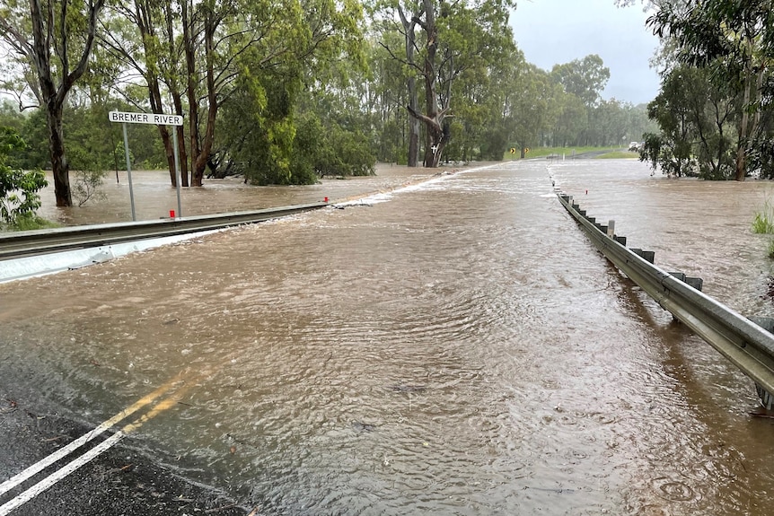Road flooded with sign reading Bremer River.