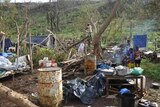 Family sits by fire among ruins of home and garden after Cyclone Pam in Vanuatu