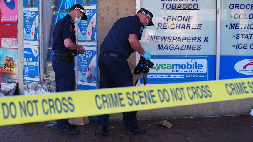 Two police officers gather evidence.