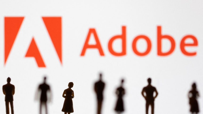 Small people figurines stand in front of an Adobe logo design