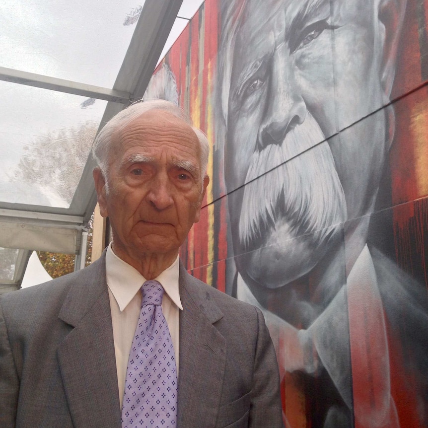 Alf Turner stands in front of a huge mural of his grandfather William Cooper in Shepparton