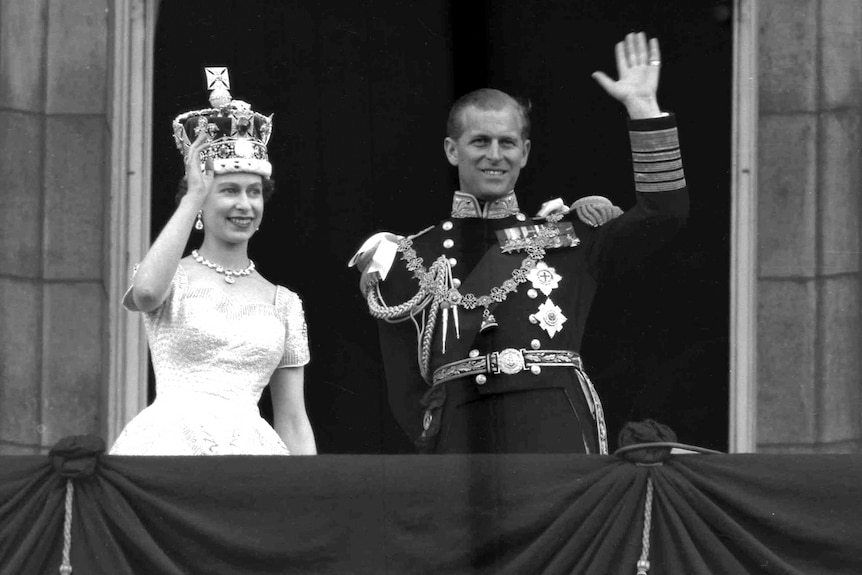 Queen Elizabeth II and Prince Philip wave from the balcony. 