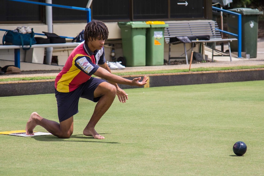 Young teenager plays bowls.