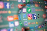 Social media logos are seen through magnifier 