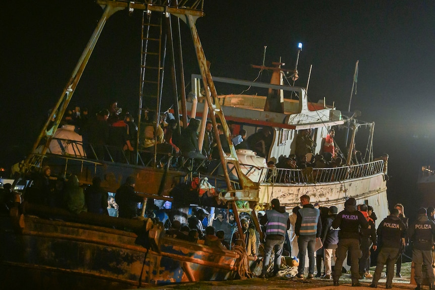 Italian police board boat packed with asylum seekers.