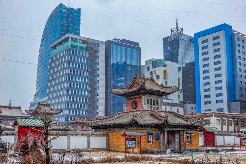 A landscape shot of a Buddhist temple and skyscrapers in the Mongolian capital city of Ulaanbaatar.