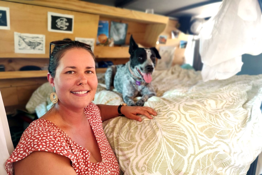 A woman in a caravan with her dog.