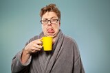 Man pulling a face at a cup of coffee