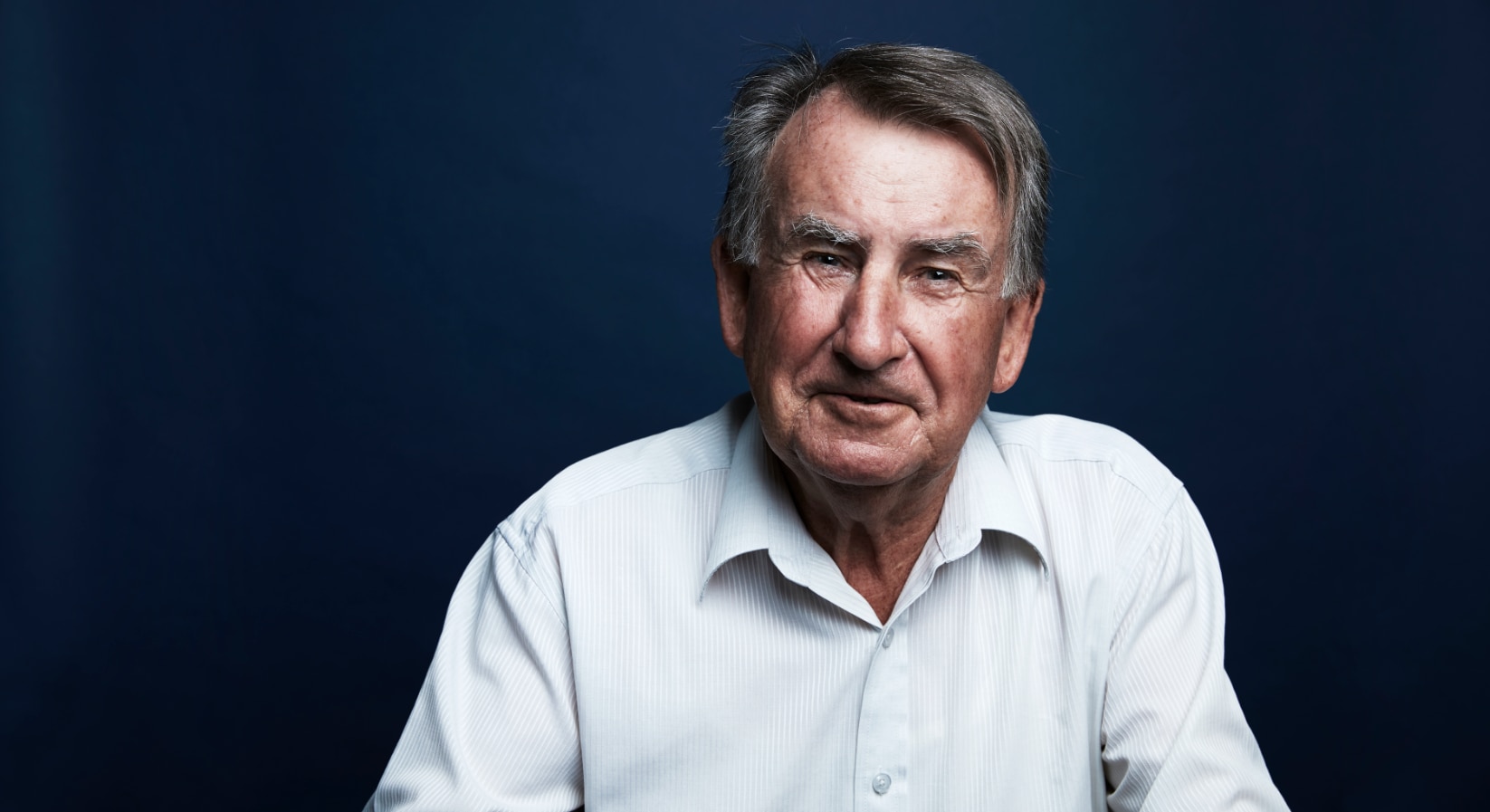 Una foto de la cabeza del autor sonriendo frente a un fondo azul.