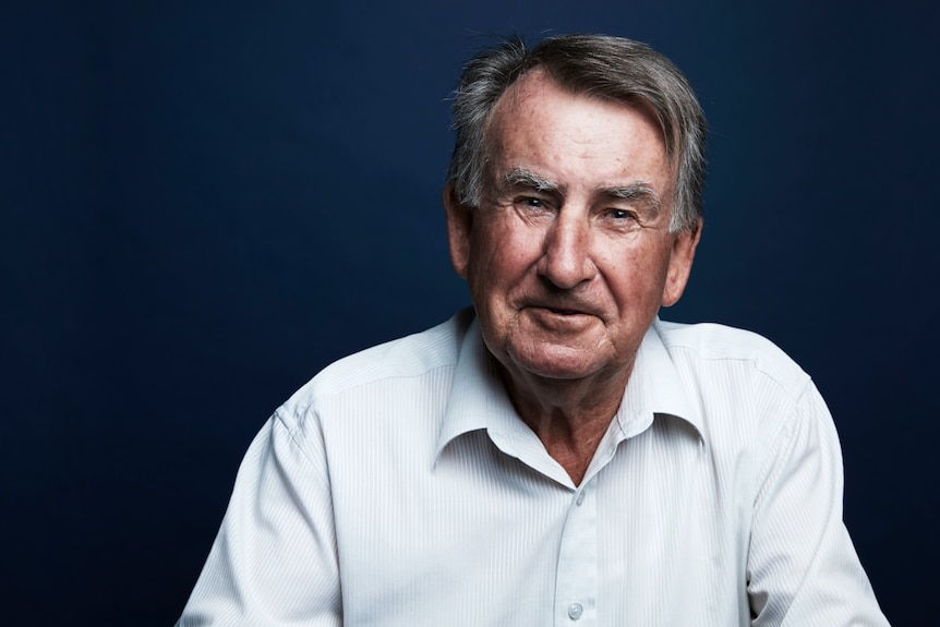 A headshot of the author smiling in front of a blue backdrop.