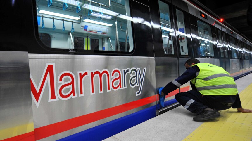 A Turkish worker cleans a train at the Uskudar Marmaray station ahead of its inauguration ceremony in Istanbul.