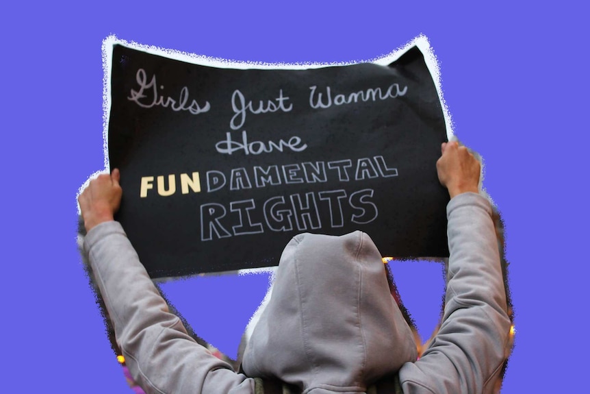 A woman at a MeToo march holds a sign that reads 'Girls just wanna have fundamental rights'