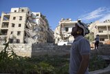Syrian rescuer looks towards the sky following an air strike in the northern Syrian city of Aleppo.