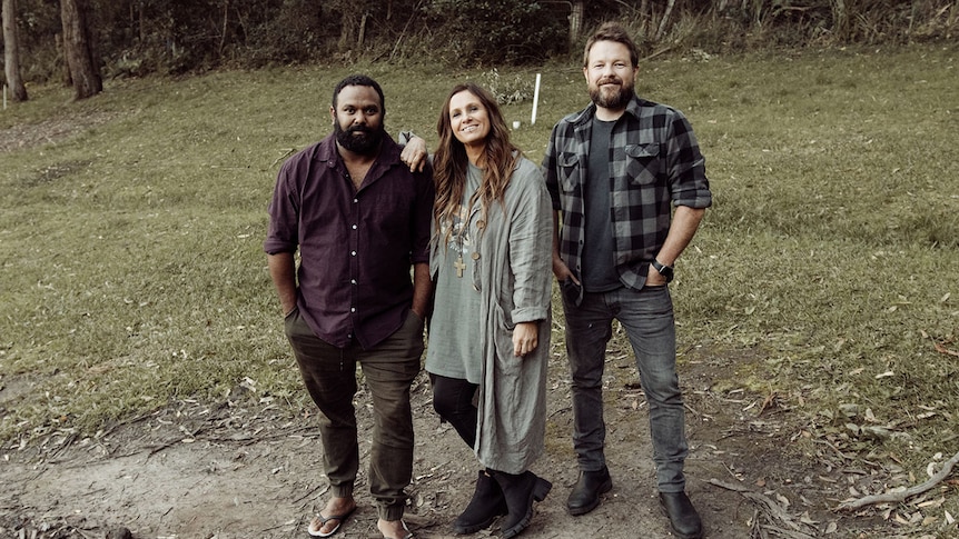 Kasey Chambers and Busby Marou stand outdoors in the bush