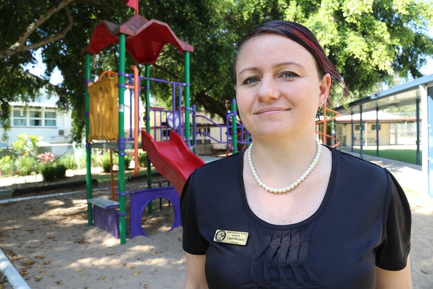 A woman stands in front of a kids' playground