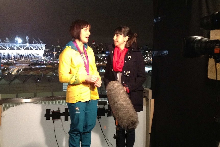 Shalala doing interview outside stadium at night.