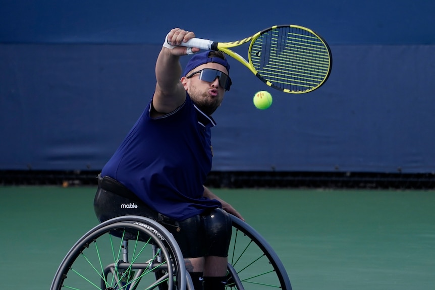 Australia's Dylan Alcott grimaces as he turns his racquet to hit a backhand return in a US Open wheelchair tennis match.
