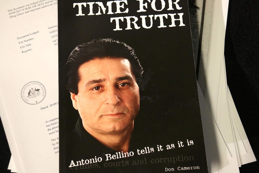 Tony Bellino's face on the cover of the book Time For Truth, which sits on top of legal papers