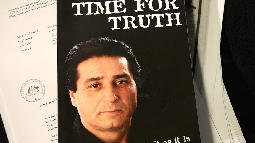 Tony Bellino's face on the cover of the book Time For Truth, which sits on top of legal papers