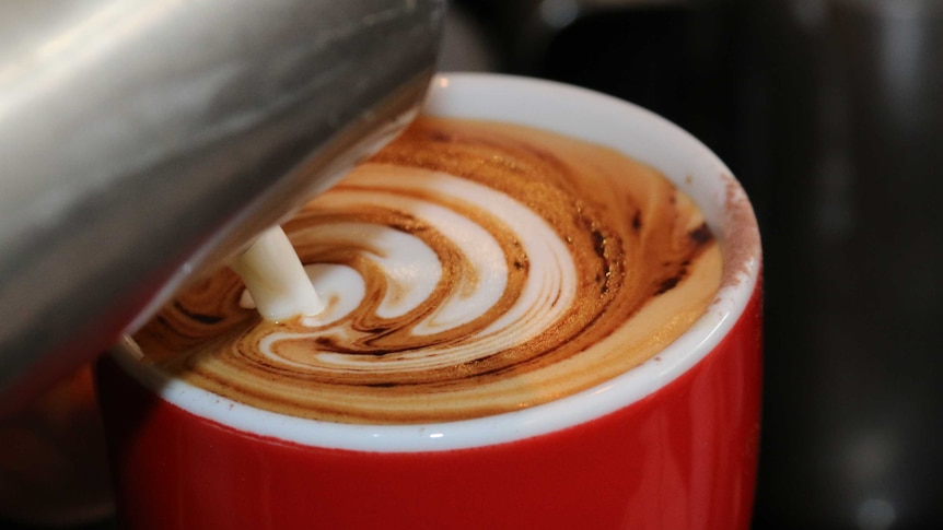 Coffee is seen being poured into a cup.