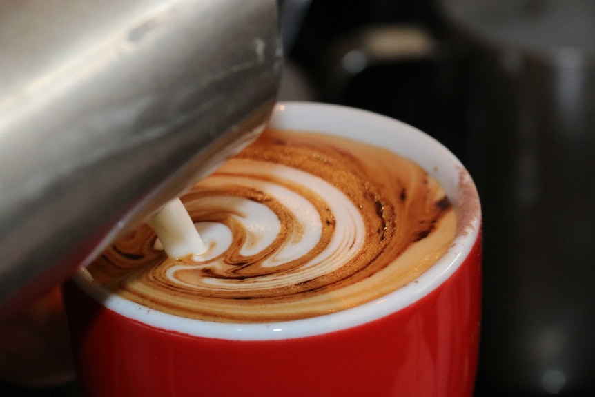 Coffee is seen being poured into a cup.