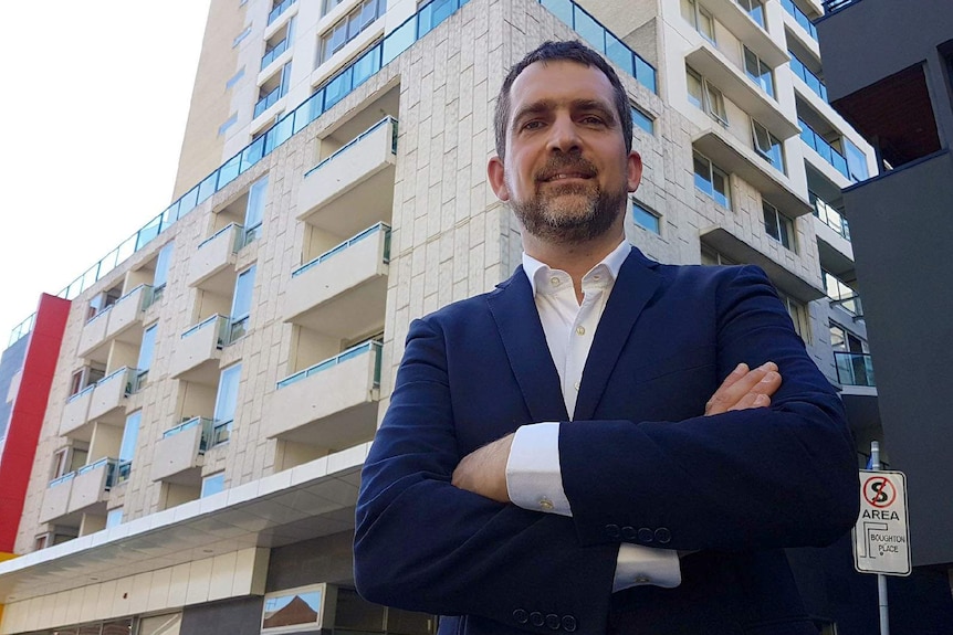 Jeremie Renard stands in front of his Melbourne apartment block.