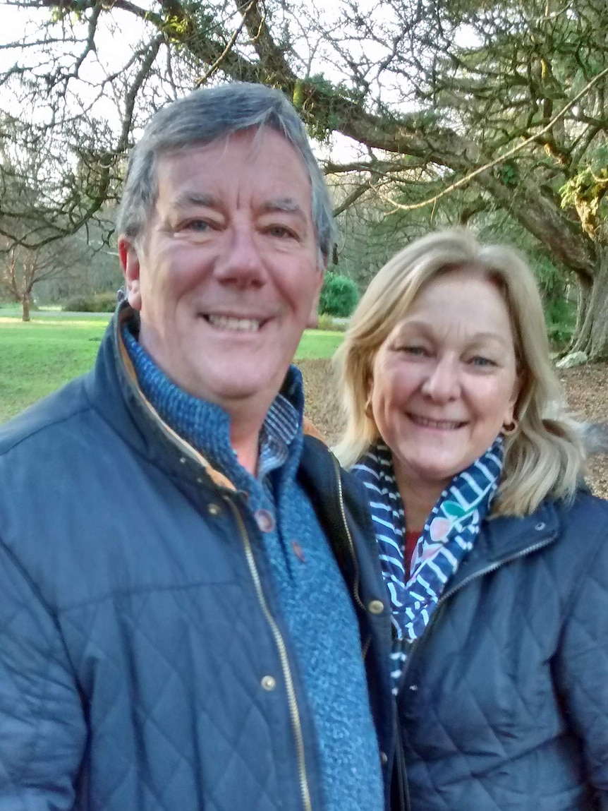 Alan and Mandy Dennison stand outside near trees.