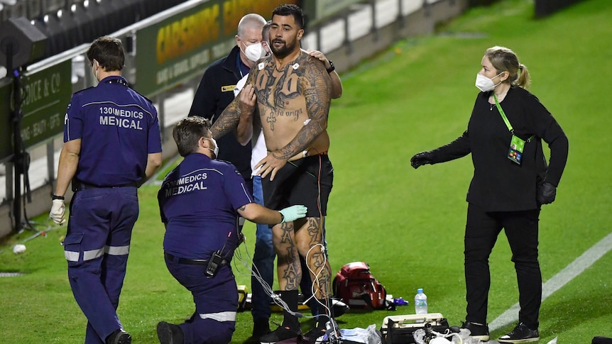 Rugby league players being attended to by medical staff during a match