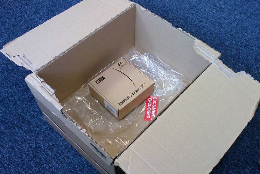 A small box with a computer gear brand label is in a much larger box with plastic which it was wrapped in for postage.