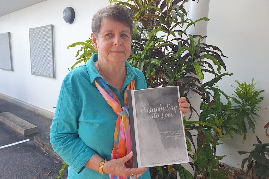 Lady in blue shirt holding booklet in her hands