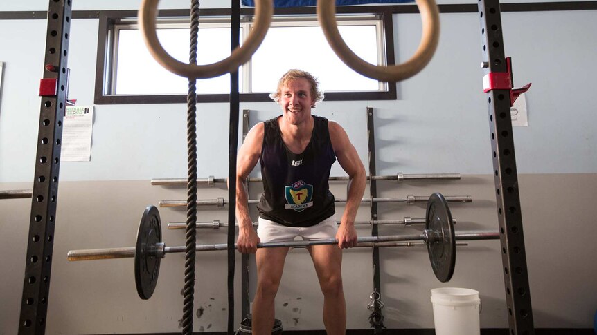 Aspiring AFL footballer training in gym, Tasmania.