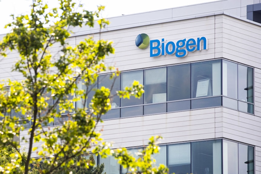 Large white building with blue and green 'Biogen' sign.