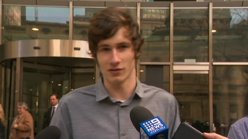 Kyan Foster stands and speaks to media outside the County Court in Melbourne.