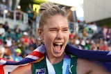 Eleanor Patterson smiles while wearing a gold medal and draped in an Australian flag at the athletics world championships.