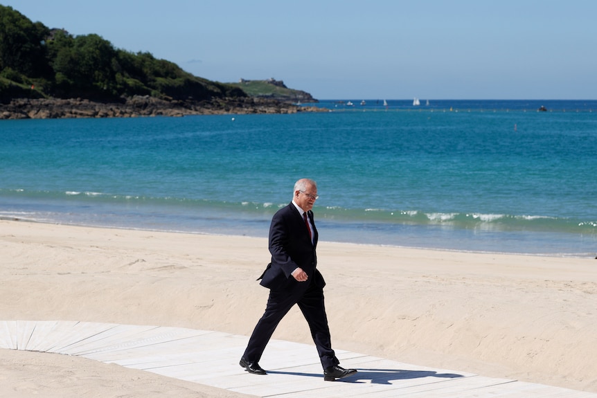 Scott Morrison walks alongside a beach in Cornwall.