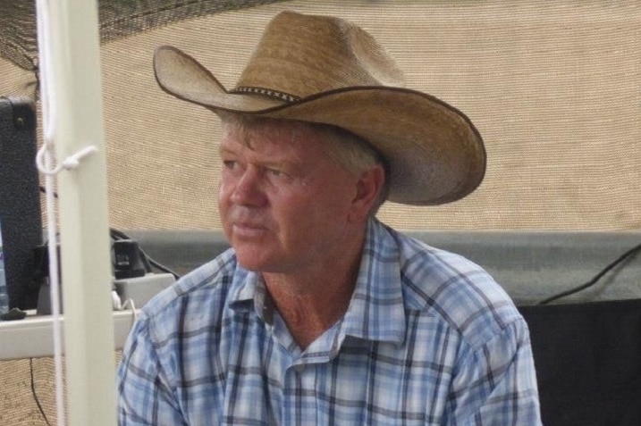 A man in a hat sitting inside a canvas tent