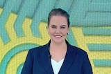Jelena Dokic wears a suit and smiles at the camera at the tennis.