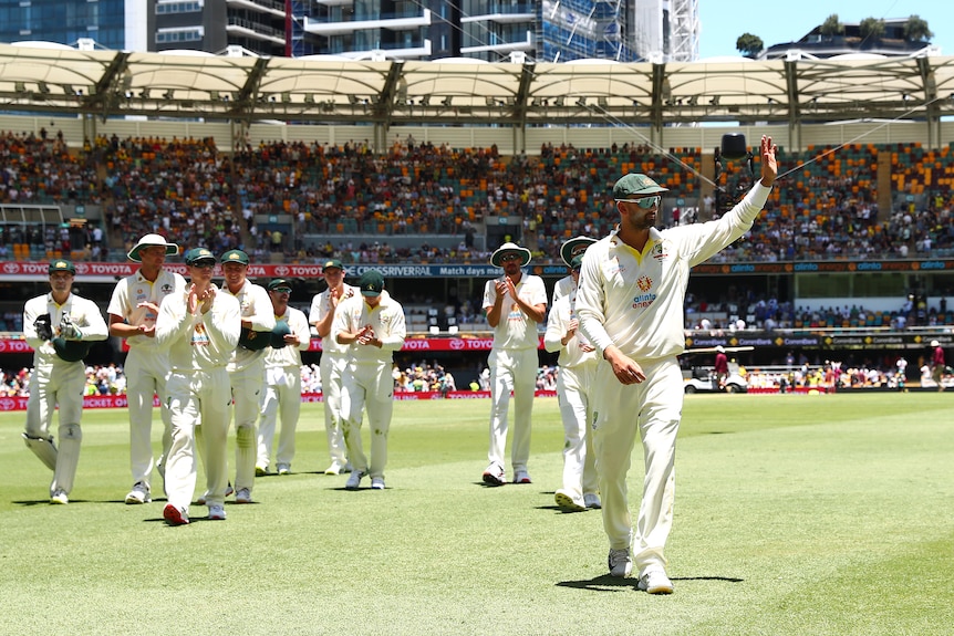 Australian cricketer Nathan Lyon waves to the crowd after taking 4 wickets during day four of the Ashes Test