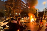 A police motorcycle burns in the street during a protest over the death of Mahsa Amini.