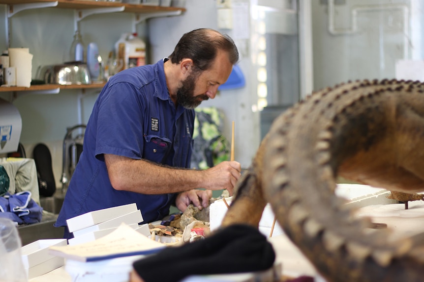 Jared Archibald works on an artefact.