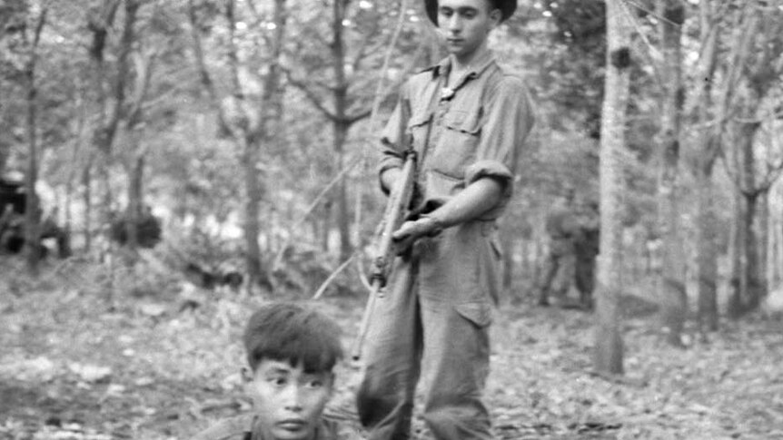 Private David J Collins guards a captured Viet Cong found hiding after battle at Long Tan