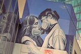 Street art of a couple wearing face masks on a Melbourne building in the CBD with skyscrapers surrounding.